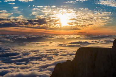 Dağlarda bulutların üstünde günbatımı manzarası