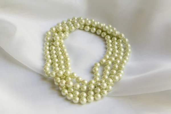 Pearl necklace on a White silk
