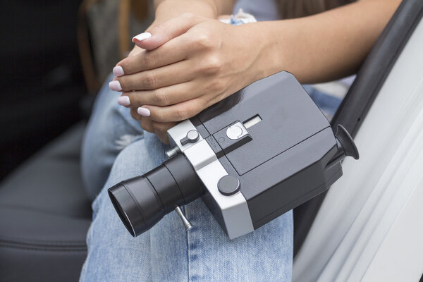 Кинокамера в руках девушки
