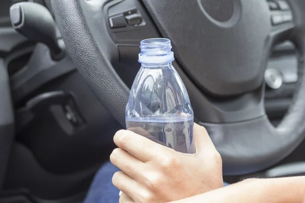 In the hands of the girl a bottle of water in the car — Stock Photo, Image