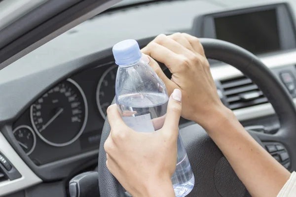 В руках девушки бутылка воды в машине — стоковое фото