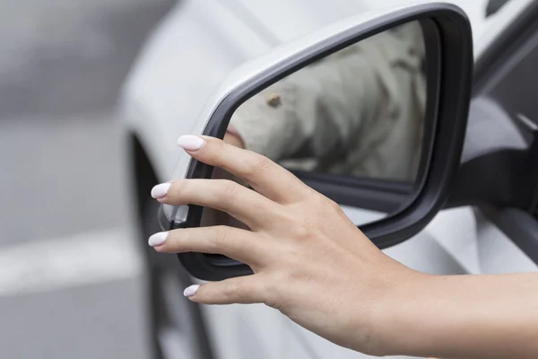 La chica en el espejo del coche se ajusta — Foto de Stock