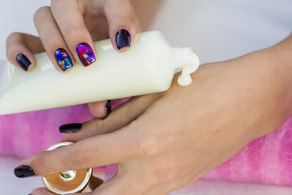 Hembra aplicando crema hidratante a sus manos . — Foto de Stock
