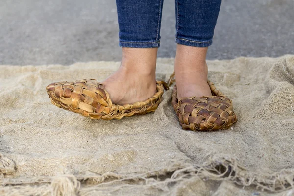 Feet girl in old Russian bast shoes