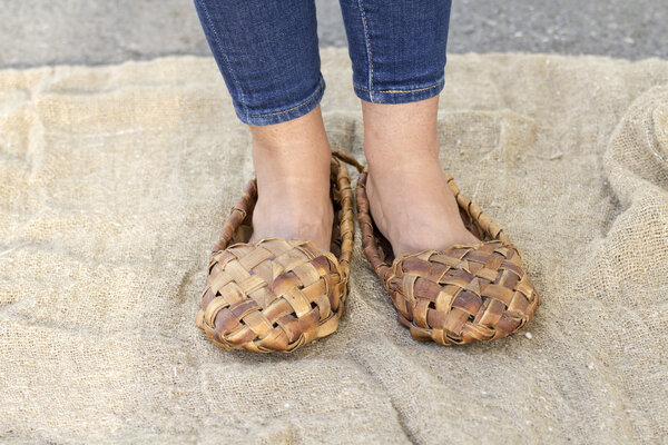 Feet girl in old Russian bast shoes 
