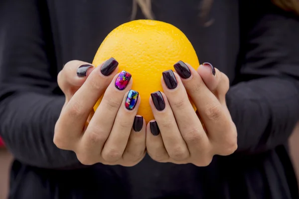 En las manos de una hembra naranja — Foto de Stock
