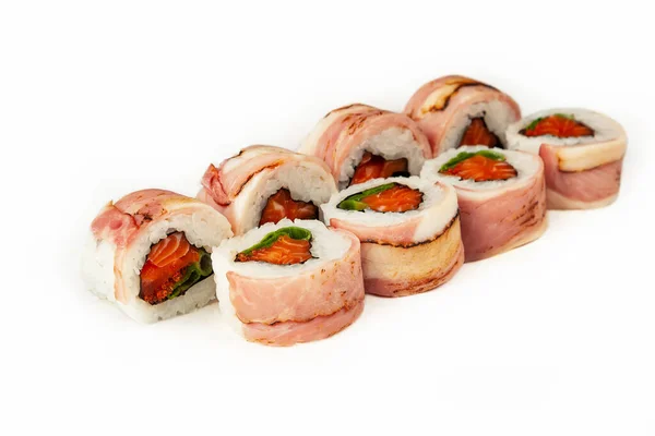 Sushi roll met spek en zalm op een witte achtergrond, ingrediënten gebakken spek, zalm, groene uien, vliegende viskuit, ijsbergsaus, rijst, nori. Traditioneel Japans eten. Voor het menu van het restaurant. — Stockfoto