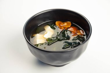 Siyah bir arabada Miso çorbası. Malzeme Suyu, Tofu peyniri, Naimeko mantarı, miso macunu, hondashi, wakame. Restoran menüsü için.