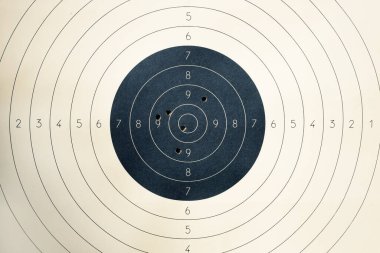 Atış poligonunda ateş etmek için numaraları olan bir hedef. Atış poligonunda atış talimi için hedef tahtası işaretli yuvarlak bir hedef. Mermi delikli hedef..