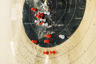 Hedef iğnelerle işaretlendi. Renkli iğneler, tetikçilerin silahtan vurduğu paneldeki hedefi gösteriyor.