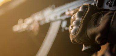 AK-47 ile Orta Doğulu ciddi bir adamın portresi.