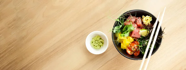 Sla met tonijn in een kom. Ingrediënten verse tonijn, kerstomaten, gemarineerd zeewier, rijst, takuan, Ponzu saus, Teriyaki saus, nori, sesamzaad, limoen, koriander. Aziatische zeevruchten salade concept. — Stockfoto