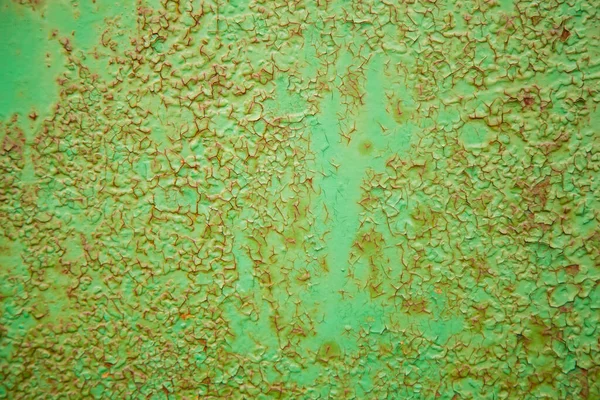 Textura de metal verde com manchas de aço ferrugem em sua superfície, tomadas ao ar livre. O padrão de uma superfície de metal pintado velho. Metal enferrujado, pintura descascando, tons verdes, cores brilhantes. — Fotografia de Stock