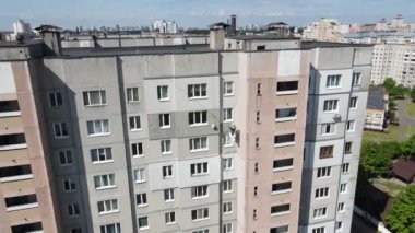 İnsansız hava aracının görüntüsü. Endüstriyel bir dağcı iplere asılmış ve çok katlı bir binanın duvarını silindirle boyuyor. Dış görünüşün yalıtımı üzerinde çalışır..
