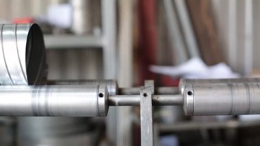 Makine paslanmaz çelik bir havalandırma borusu üretiyor. Havalandırma boruları üretmek için ekin. Fabrika metal havalandırma boruları üretiyor..