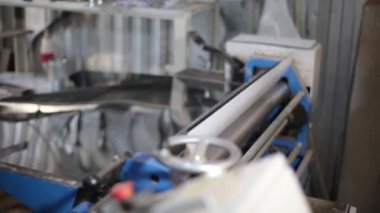 Makine paslanmaz çelikten bir levhayı boruya büker. Havalandırma ve su birikintisi fabrikasında dört rulo plaka bükme makinesi. Metal levha bükmek için aletler ve ekipmanlar.