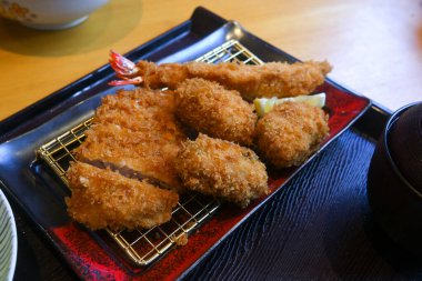İstiridye tempura, karides tempura ve tonkatsu popüler bir Japon yemeği tepsisi üzerinde servis edilir.