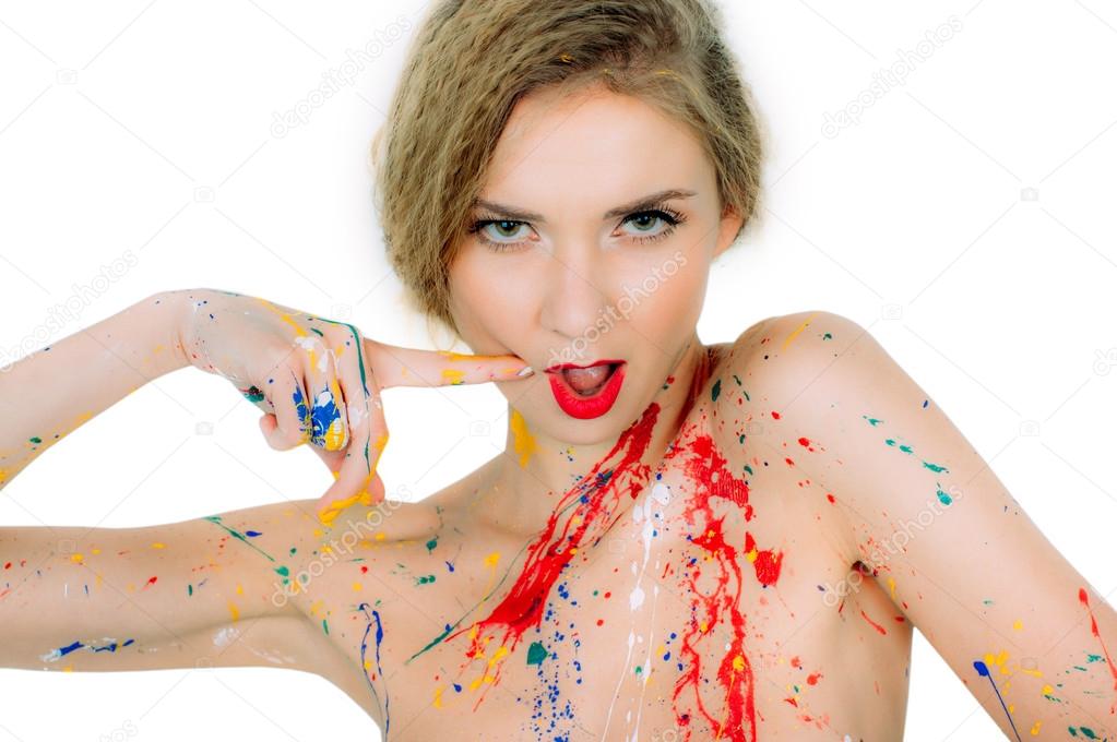 Crazy colorful  portrait of young beautiful woman in paint with finger near red lips