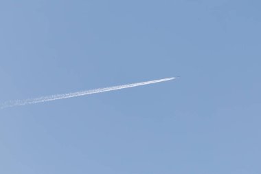 Çift motorlu, zıt yönlü, yüksek irtifada uçan, açık mavi gökyüzü.