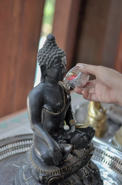 Buda heykeli üzerine su dökerek