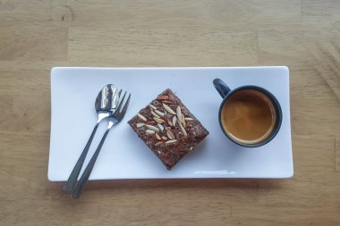 ahşap arka plan üzerinde plaka ve kahve kupa üzerinde çikolatalı kek