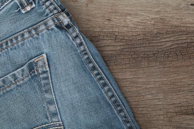 Mavi jeans kahverengi ahşap arka plan üzerinde