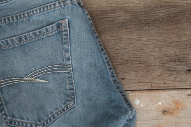 Mavi jeans kahverengi ahşap arka plan üzerinde