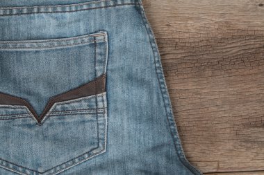 Mavi jeans kahverengi ahşap arka plan üzerinde