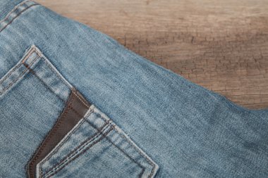 Mavi jeans kahverengi ahşap arka plan üzerinde