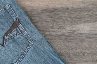 Mavi jeans kahverengi ahşap arka plan üzerinde