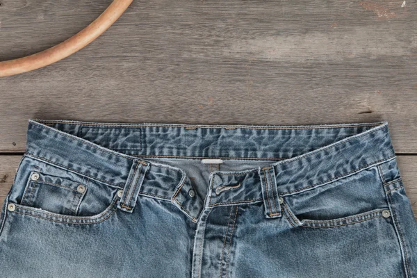 Calça jeans azul em um fundo de madeira marrom — Fotografia de Stock