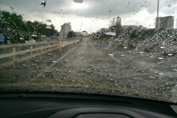 Θέα στο δρόμο μέσα από το αυτοκίνητο παράθυρο θολή με βαριά βροχή, οδήγηση σε βροχή, βροχερός καιρός Royalty Free Εικόνες Αρχείου