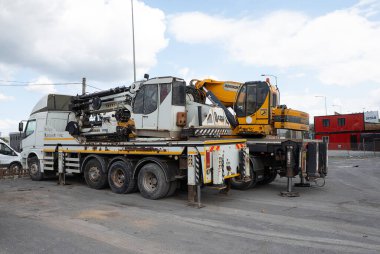 Büyük beyaz ve sarı Hidromek HMK 310 vinç bir kamyon üzerine monte edilmiştir.