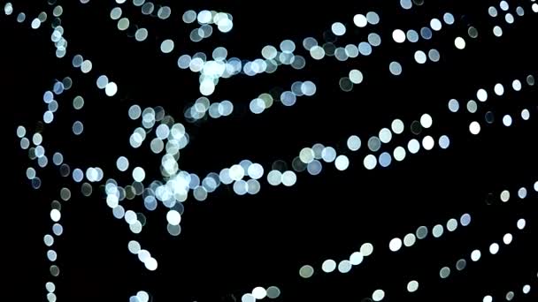 Schöne weiße Bokeh LED-Lichter blinkt in der Nacht. — Stockvideo