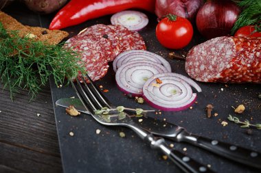 Sebze, soğan ve baharatlı otlar ile dilimlenmiş salam