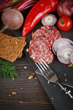 Sebze, soğan ve baharatlı otlar ile dilimlenmiş salam