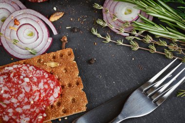 Sebze, soğan ve baharatlı otlar ile dilimlenmiş salam