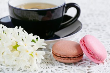 Fincan yeşil çay, renk acıbadem kurabiyesi ve beyaz çiçekler