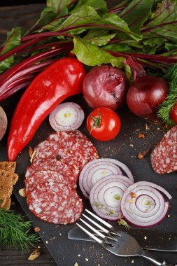 Sebze, soğan ve baharatlı otlar ile dilimlenmiş salam