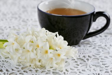 Fincan yeşil çay, renk acıbadem kurabiyesi ve beyaz çiçekler