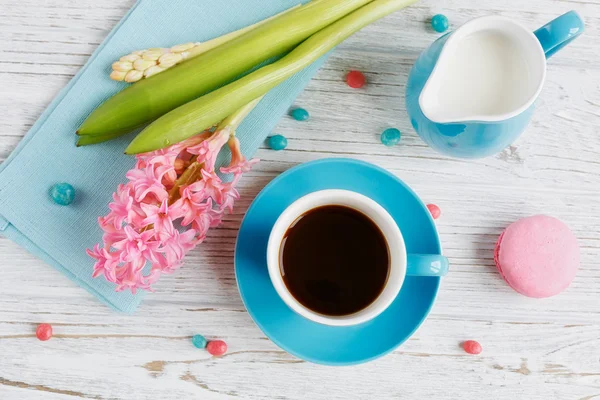 Tasse schwarzen Kaffee, rosa Blumen und französische Makronen — Stockfoto