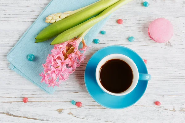 Kubek czarnej kawy, różowe kwiaty i francuski macaroons — Zdjęcie stockowe