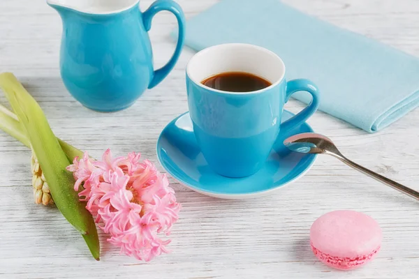 Tasse schwarzen Kaffee, rosa Blumen und französische Makronen — Stockfoto