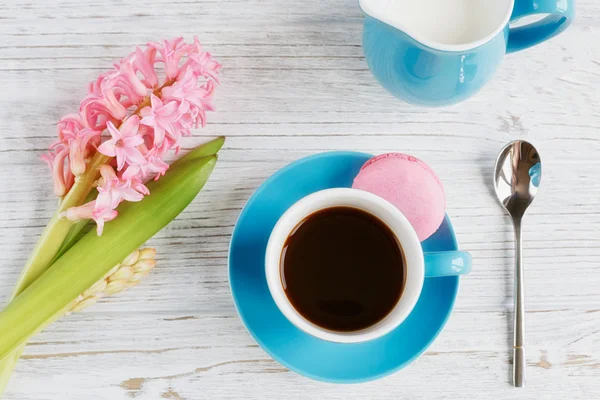 Taza de café negro, flores rosadas y macarrones franceses — Foto de Stock