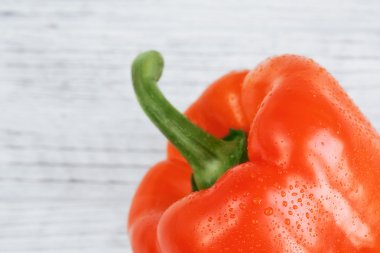 Beyaz ahşap zemin üzerinde turuncu kırmızı biber (biber)