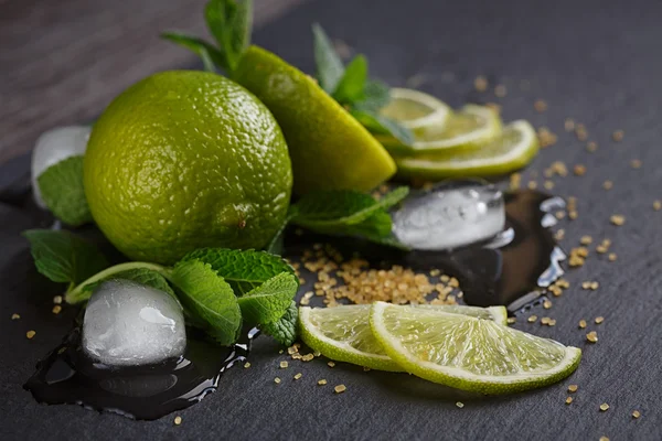 Fresh lime, mint and ice cubes. Dark background — Stock Photo, Image
