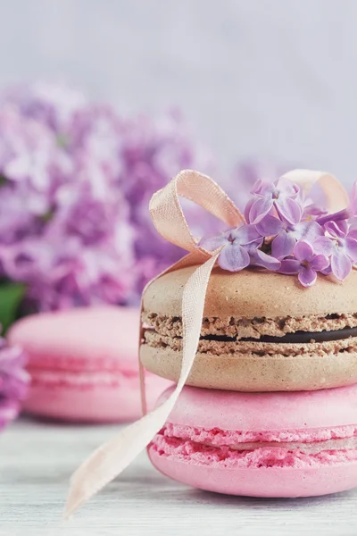 Tasse schwarzen Kaffee, fliederfarbene Blumen und süße pastellfarbene Macar — Stockfoto