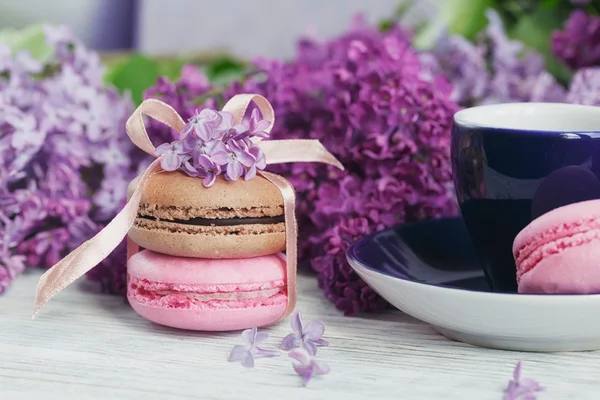 Kopje zwarte koffie, lila bloemen en zoete pastel Franse macar — Stockfoto