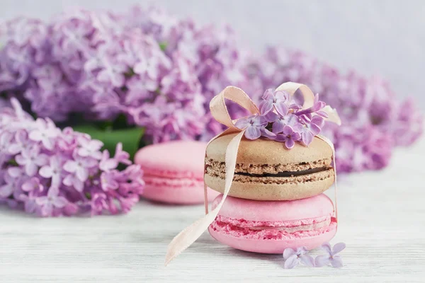 Kopje zwarte koffie, lila bloemen en zoete pastel Franse macar — Stockfoto