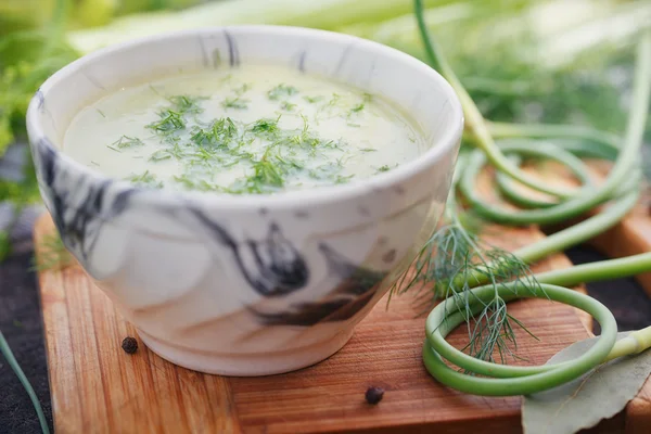 Skål med grön grädde soppa på träbord — Stockfoto